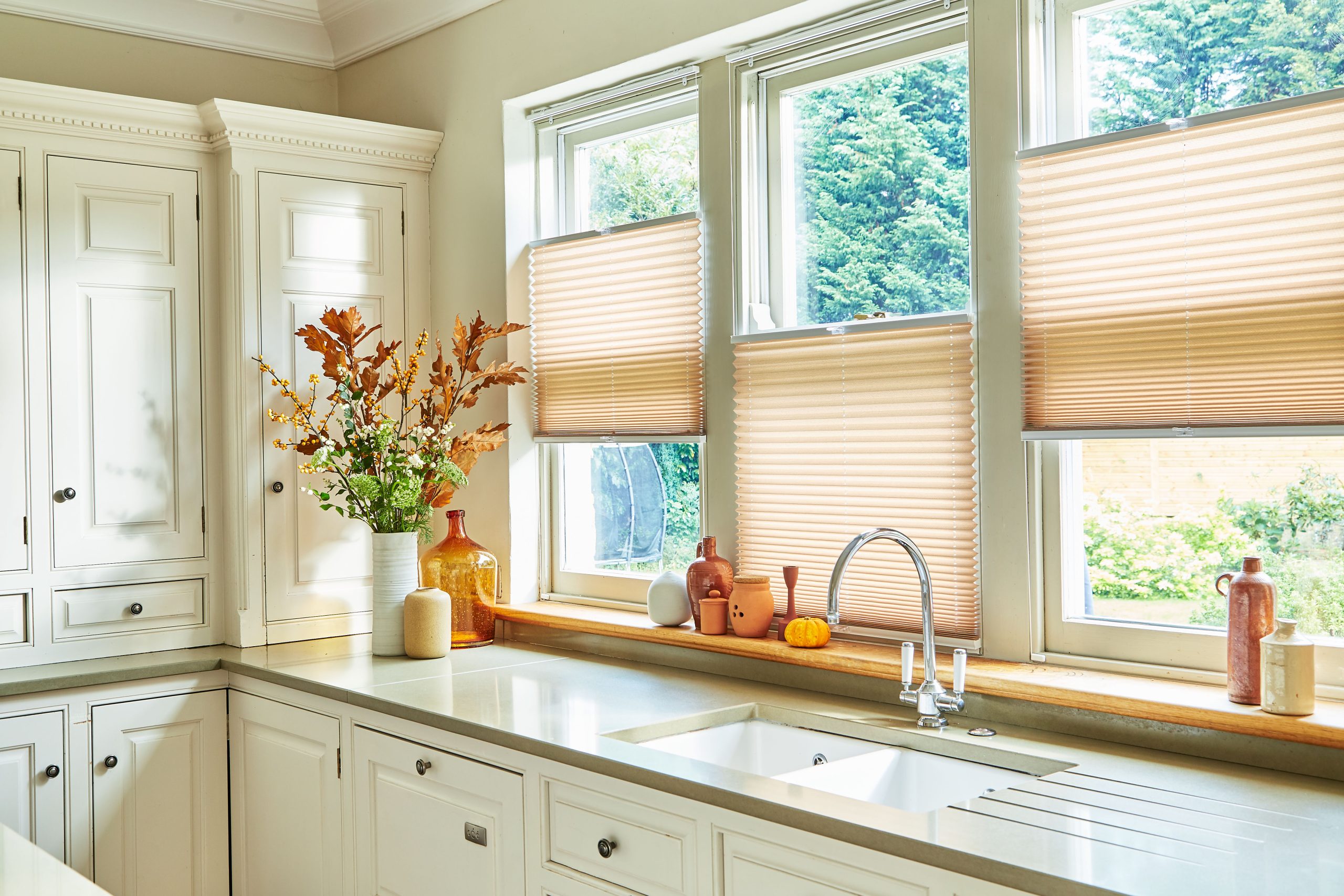 Pleated blinds in terracotta tone within a styled interior